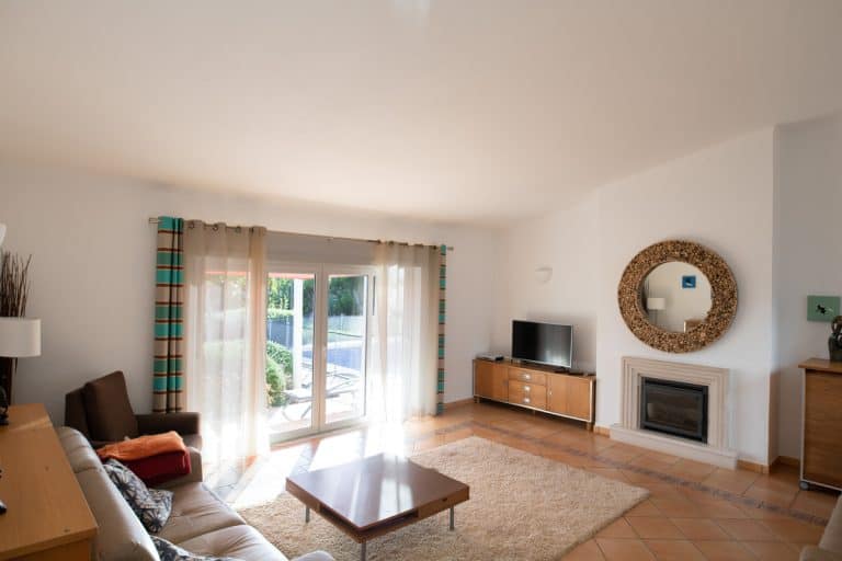 Living room with tiled floors, patio doors and high sloping ceiling, How High To Hang Curtains Above Sliding Doors?